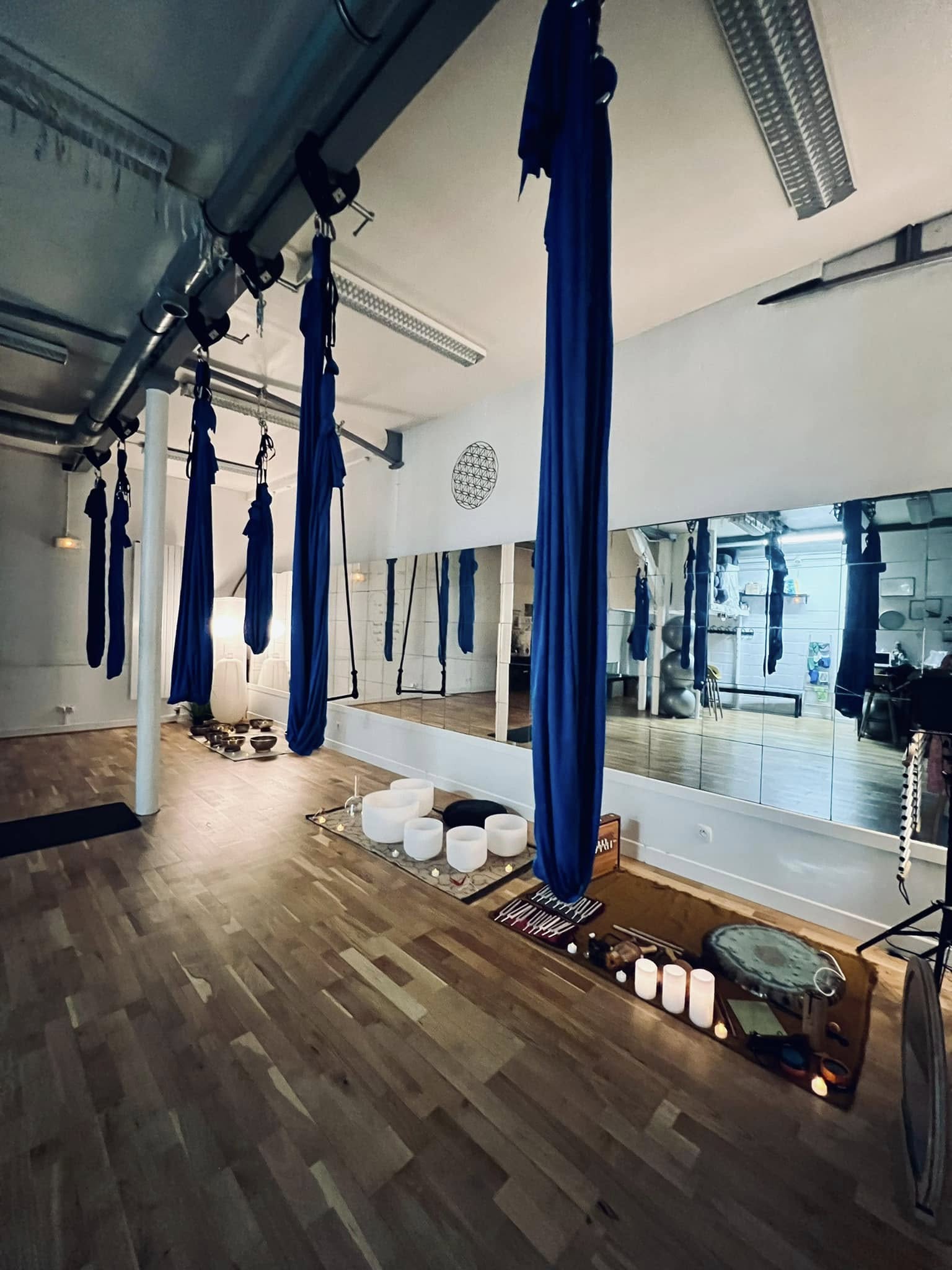 Installation de bols de cristal et d’instruments sonores sous des hamacs suspendus dans un studio parisien