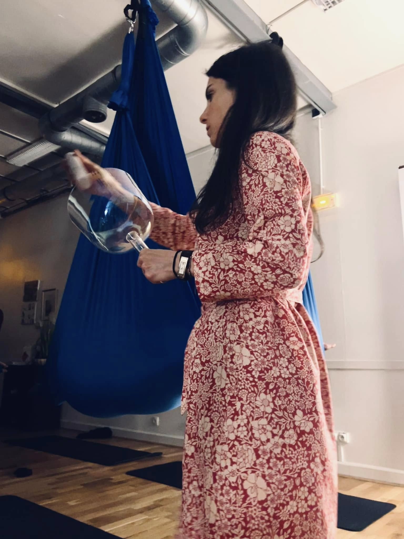 Mélanie Zadeh jouant d’un bol de cristal auprès d’un participant installé dans un hamac