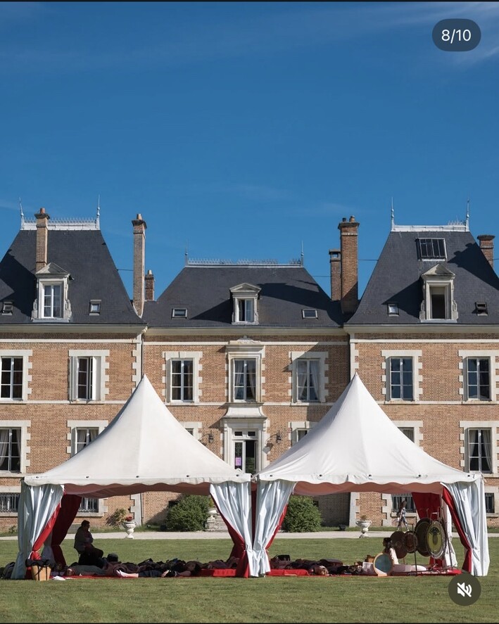 Tentes installées devant un château pour accueillir un bain sonore collectif en plein air