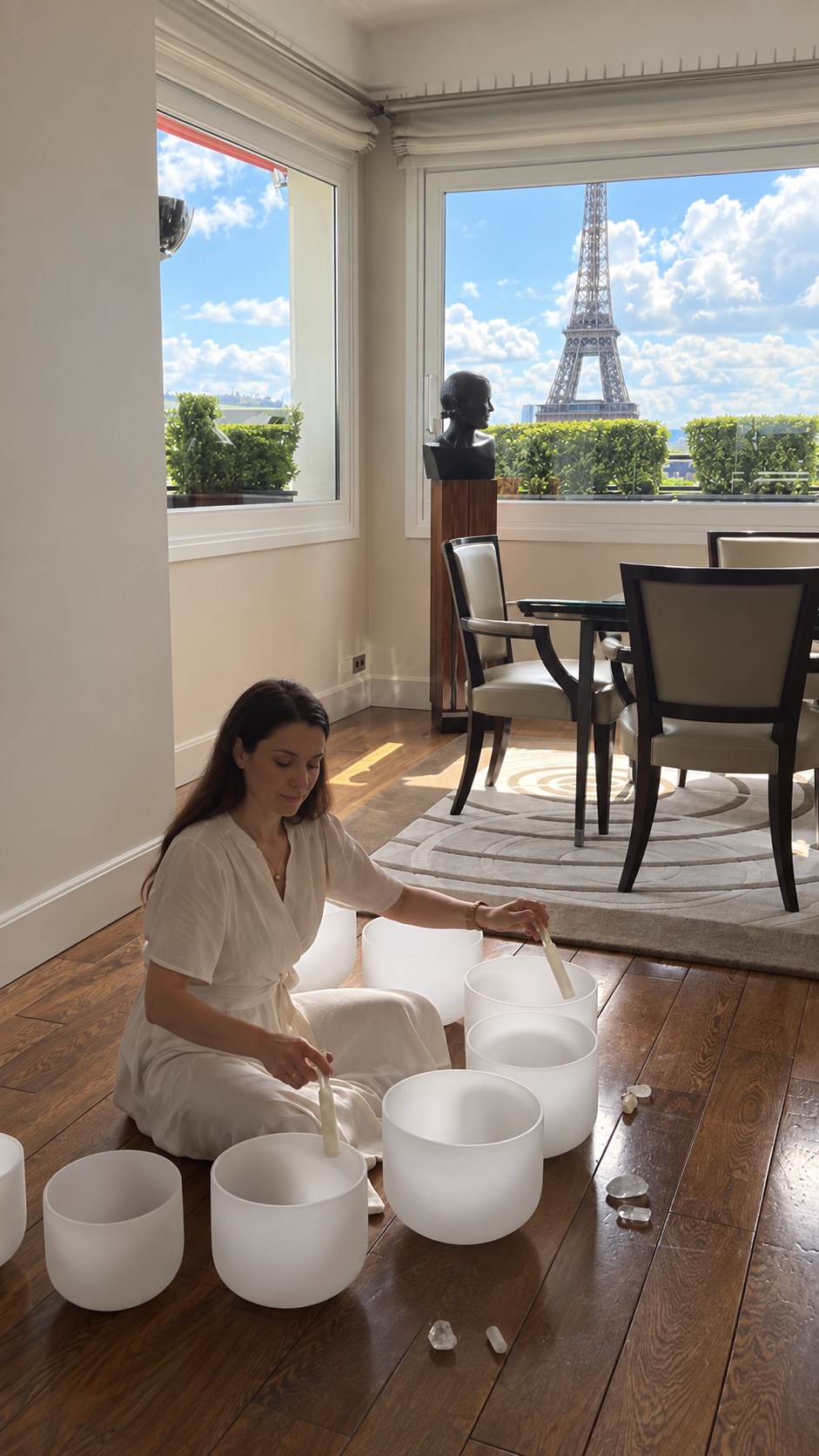 Mélanie Zadeh jouant des bols de cristal dans une chambre du Plaza Athénée avec vue sur la tour Eiffel
