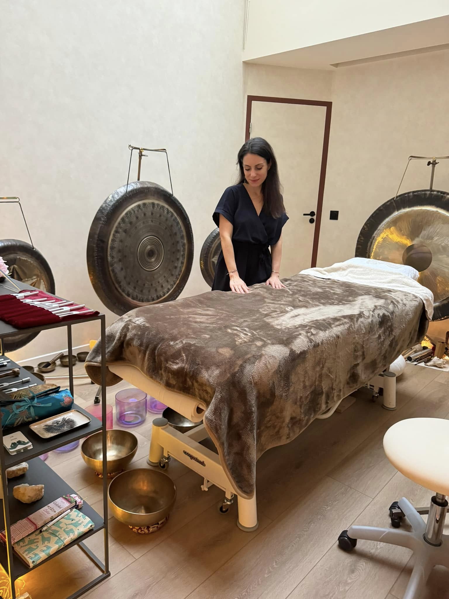 Soin sonore individuel autour d’une table de soin entourée de gongs, de bols et de diapasons